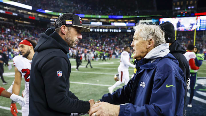 Dec 15, 2022; Seattle, Washington, USA; San Francisco 49ers head coach Kyle Shanahan, left, shakes hands with Seattle Seahawks head coach Pete Carroll following a 21-13 San Francisco victory at Lumen Field. Mandatory Credit: Joe Nicholson-Imagn Images