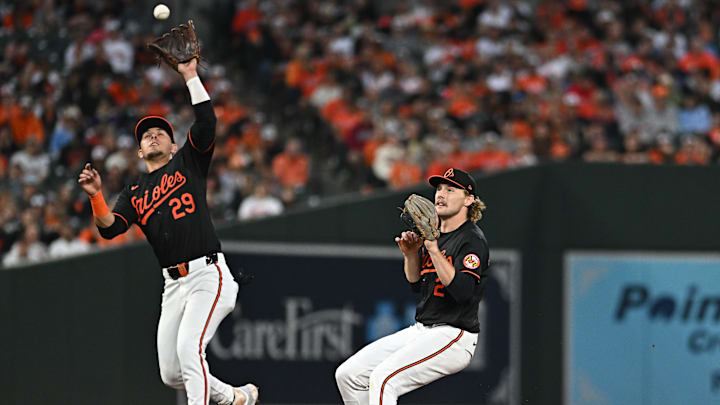 Oct 2, 2024; Baltimore, Maryland, USA; Baltimore Orioles third baseman Ramon Urias (29) fields the ball as Orioles shortstop Gunnar Henderson (2) looks on against the Kansas City Royals in the sixth inning in game two of the Wild Card round for the 2024 MLB Playoffs at Oriole Park at Camden Yards. Mandatory Credit: Tommy Gilligan-Imagn Images
