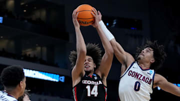 Mar 20, 2025; Wichita, KS, USA; Georgia Bulldogs forward Asa Newell (14) and Gonzaga Bulldogs guard Ryan Nembhard (0) fight for a rebound in the first half of a first round men’s NCAA Tournament game at Intrust Bank Arena. Mandatory Credit: Kirby Lee-Imagn Images