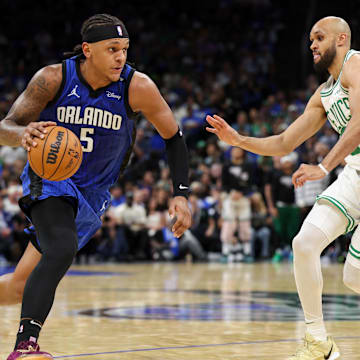 Apr 27, 2025; Orlando, Florida, USA; Orlando Magic forward Paolo Banchero (5) is guarded by Boston Celtics guard Derrick White (9) in the second quarter during game four of first round for the 2025 NBA Playoffs at Kia Center. Mandatory Credit: Nathan Ray Seebeck-Imagn Images