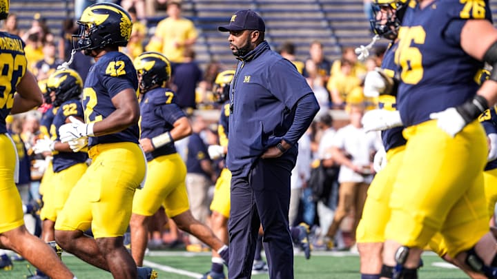 Michigan head coach Sherrone Moore, center, watches warmup ahead of the Washington game at Michigan Stadium in Ann Arbor on Saturday, Oct. 18, 2025.