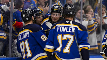 Mar 20, 2025; St. Louis, Missouri, USA;  St. Louis Blues defenseman Philip Broberg (6) is congratulated by center Dylan Holloway (81) center Oskar Sundqvist (70) and defenseman Cam Fowler (17) after scoring the game winning goal against the Vancouver Canucks in overtime at Enterprise Center. Mandatory Credit: Jeff Curry-Imagn Images