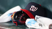 May 30, 2024; Atlanta, Georgia, USA; A detailed view of a Washington Nationals hat and glove on the bench against the Atlanta Braves in the ninth inning at Truist Park. Mandatory Credit: Brett Davis-Imagn Images