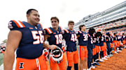 Nov 1, 2025; Champaign, Illinois, USA;  The Illinois Fighting Illini team stands as the band plays the school fight song after a win against the Rutgers Scarlet Knights at Memorial Stadium. Mandatory Credit: Ron Johnson-Imagn Images