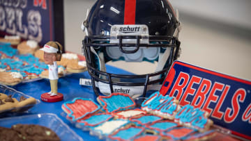 Ole Miss Themed material including a helmet, baked cookies, and a bobblehead Lane Kiffin figure sits on a table during the Cam Clark Ole Miss signing in Medina, Tenn., on Wednesday, Dec. 20, 2023.