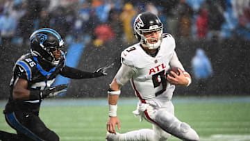 Dec 17, 2023; Charlotte, North Carolina, USA; Atlanta Falcons quarterback Desmond Ridder (9) runs as Carolina Panthers safety Xavier Woods (25) defends in the fourth quarter at Bank of America Stadium. Mandatory Credit: Bob Donnan-Imagn Images