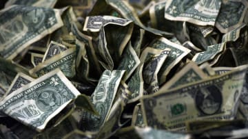 A pile of dollar bills sits on a table on Saturday, December 11, 2021.