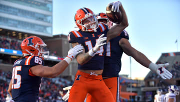 Nov 25, 2023; Champaign, Illinois, USA; Illinois Fighting Illini wide receiver Casey Washington (14) celebrates a touchdown with teammates during the first half against the Northwestern Wildcats  at Memorial Stadium. Mandatory Credit: Ron Johnson-USA TODAY Sports
