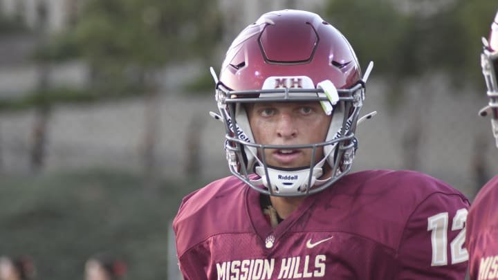 Mission Hills junior quarterback Troy Huhn warms up prior to the 2024 season opener