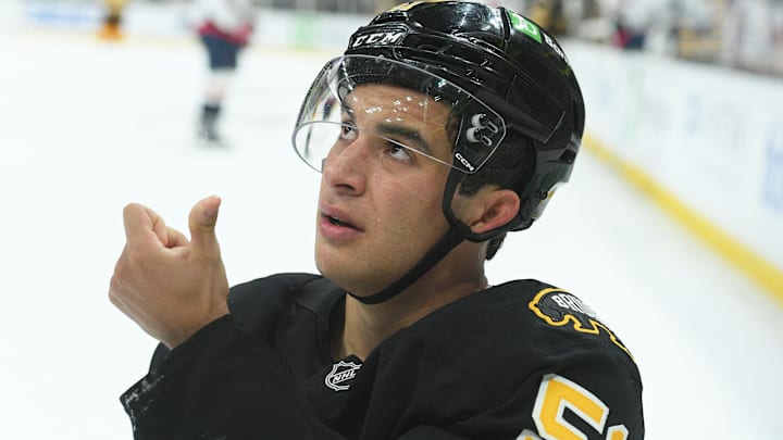 Sep 21, 2025; Boston, Massachusetts, USA; Boston Bruins center Matthew Poitras (51) shows the official blood from his mouth after getting hit in the mouth during the third period against the Washington Capitals at TD Garden. Mandatory Credit: Bob DeChiara-Imagn Images