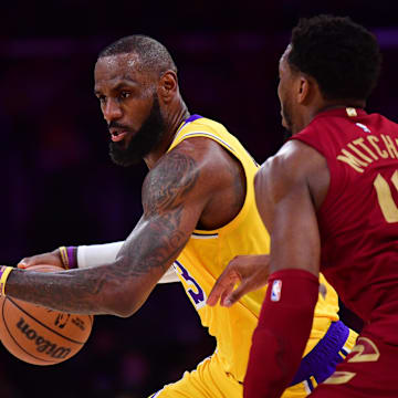Dec 31, 2024; Los Angeles, California, USA; Los Angeles Lakers forward LeBron James (23) moves the ball against Cleveland Cavaliers guard Donovan Mitchell (45) during the first half at Crypto.com Arena. Mandatory Credit: Gary A. Vasquez-Imagn Images