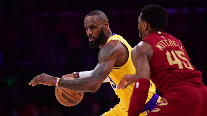 Dec 31, 2024; Los Angeles, California, USA; Los Angeles Lakers forward LeBron James (23) moves the ball against Cleveland Cavaliers guard Donovan Mitchell (45) during the first half at Crypto.com Arena. Mandatory Credit: Gary A. Vasquez-Imagn Images