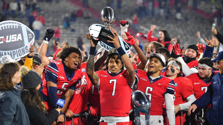 Dec 1, 2023; Lynchburg, VA, USA; Liberty Flames quarterback Kaidon Salter (7) holds up the Conference USA MVP trophy after the game against the New Mexico State Aggies at Williams Stadium. Mandatory Credit: Brian Bishop-USA TODAY Sports