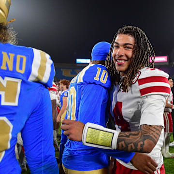 Nebraska quarterback TJ Lateef (14) meets with UCLA backup quarterback Madden Iamaleava after Saturday's game.