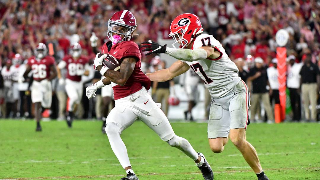 Sep 28, 2024; Tuscaloosa, Alabama, USA;  Alabama Crimson Tide wide receiver Ryan Williams (2) evades Georgia Bulldogs quarterback Colter Ginn (17) after a pass reception at Bryant-Denny Stadium. Alabama defeated Georgia 41-34. Mandatory Credit: Gary Cosby Jr.-Imagn Images
