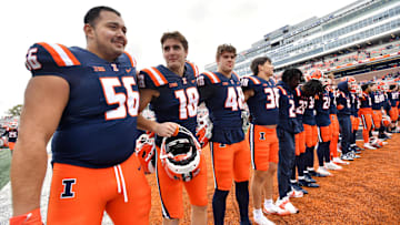 Nov 1, 2025; Champaign, Illinois, USA;  The Illinois Fighting Illini team stands as the band plays the school fight song after a win against the Rutgers Scarlet Knights at Memorial Stadium. Mandatory Credit: Ron Johnson-Imagn Images
