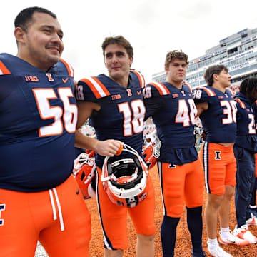 Nov 1, 2025; Champaign, Illinois, USA;  The Illinois Fighting Illini team stands as the band plays the school fight song after a win against the Rutgers Scarlet Knights at Memorial Stadium. Mandatory Credit: Ron Johnson-Imagn Images
