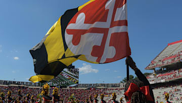 Sep 2, 2023; College Park, Maryland, USA; A member of the Maryland Terrapins spirit team holds a state flag before the game against the Towson Tigers  at SECU Stadium. Mandatory Credit: Tommy Gilligan-Imagn Images