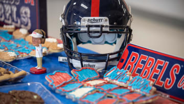 Ole Miss Themed material including a helmet, baked cookies, and a bobblehead Lane Kiffin figure sits on a table during the Cam Clark Ole Miss signing in Medina, Tenn., on Wednesday, Dec. 20, 2023.