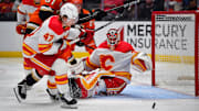 Jan 7, 2025; Anaheim, California, USA; Calgary Flames goaltender Dustin Wolf (32) defends the goal as center Connor Zary (47) moves in for the rebound against Anaheim Ducks left wing Cutter Gauthier (61) during the second period at Honda Center. Mandatory Credit: Gary A. Vasquez-Imagn Images