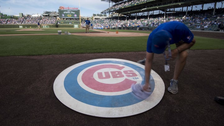 Jun 19, 2017; Chicago, IL, USA; A member of the grounds crew wipes off the Chicago Cubs' on deck logo prior to a game against the San Diego Padres at Wrigley Field. 