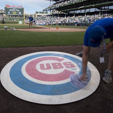 Jun 19, 2017; Chicago, IL, USA; A member of the grounds crew wipes off the Chicago Cubs' on deck logo prior to a game against the San Diego Padres at Wrigley Field. Mandatory Credit: Patrick Gorski-Imagn Images
