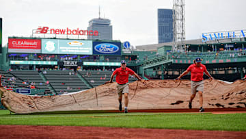 Jun 14, 2024; Boston, Massachusetts, USA; The Red Sox ground crew roll out the in-field tarp in anticipation of rain before a game against the New York Yankees at Fenway Park. Mandatory Credit: Eric Canha-Imagn Images