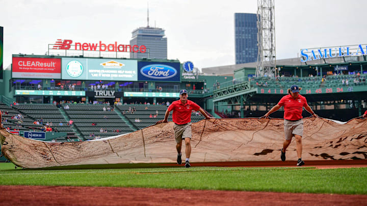 Jun 14, 2024; Boston, Massachusetts, USA; The Red Sox ground crew roll out the in-field tarp in anticipation of rain before a game against the New York Yankees at Fenway Park. Mandatory Credit: Eric Canha-Imagn Images