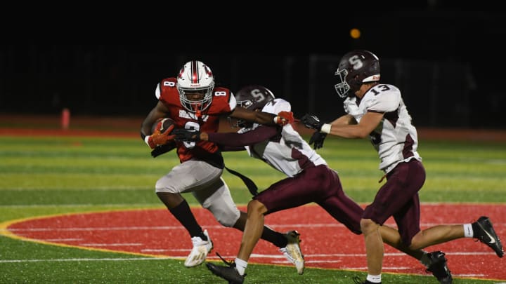 Two defenders attempt to tackle Lex Cyrus (8) during Shippensburg's game against Susquehanna Twp. on Thursday, September 21, 2023. The Greyhounds lost 28-19