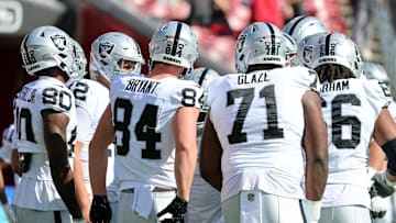 Dec 8, 2024; Tampa, Florida, USA; Las Vegas Raiders quarterback Aidan O'Connell (12) and teammates huddle up before the game against the Tampa Bay Buccaneers at Raymond James Stadium. Mandatory Credit: Kim Klement Neitzel-Imagn Images
