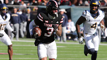 Nov 30, 2024; Lubbock, Texas, USA;  Texas Tech Red Raiders wide receiver Josh Kelly (3) runs the ball against West Virginia Mountaineers defensive back Trey Lathan (4) in the first half at Jones AT&T Stadium and Cody Campbell Field. Mandatory Credit: Michael C. Johnson-Imagn Images