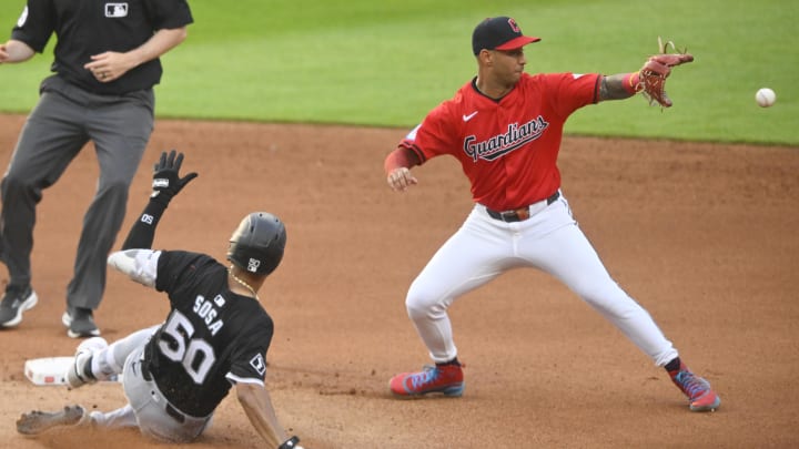 Jul 3, 2024; Cleveland, Ohio, USA; Cleveland Guardians shortstop Brayan Rocchio (4) reaches for the ball as Chicago White Sox third baseman Lenyn Sosa (50) slide to second base on a double in the fourth inning at Progressive Field. Mandatory Credit: David Richard-USA TODAY Sports