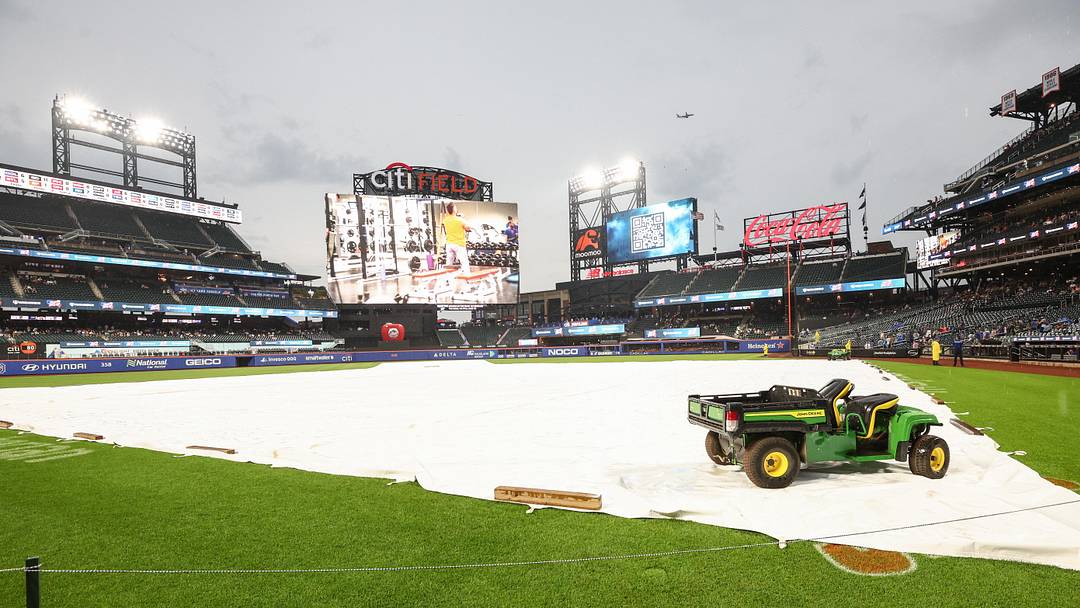 Aug 13, 2025; New York City, New York, USA;  The tarp iis placed on the field during a rain delay prior to the game between the Atlanta Braves and the New York Mets at Citi Field. Mandatory Credit: Wendell Cruz-Imagn Images