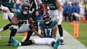Dec 7, 2025; Jacksonville, Florida, USA;  Jacksonville Jaguars wide receiver Tim Patrick (17) sits on the field after catching a touchdown pass, as teammates tight end Brenton Strange (85) and quarterback Trevor Lawrence (16) join in against the Indianapolis Colts during the first half at EverBank Stadium. Mandatory Credit: Matt Pendleton-Imagn Images