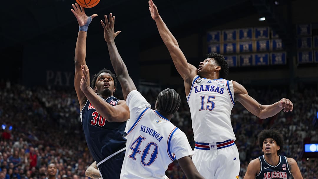 Feb 7, 2026; Lawrence, Kansas, USA; Arizona Wildcats forward Tobe Awaka (30) shoots against Kansas Jayhawks forward Flory Bidunga (40) and forward Bryson Tiller (15) during the first half at Allen Fieldhouse. Mandatory Credit: Jay Biggerstaff-Imagn Images