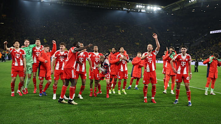 Bayern Munich players celebrating with visiting fans at Signal Iduna Park after defeating Borussia Dortmund in the Bundesliga.