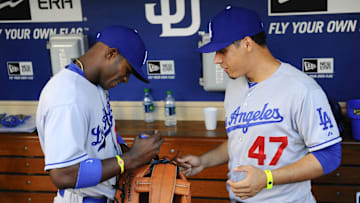 June 20, 2013; San Diego, CA, USA; Los Angeles Dodgers right fielder Yasiel Puig (66) and third baseman Luis Cruz (47) sign a giant glove in the dugout prior to the game against the San Diego Padres at Petco Park. 