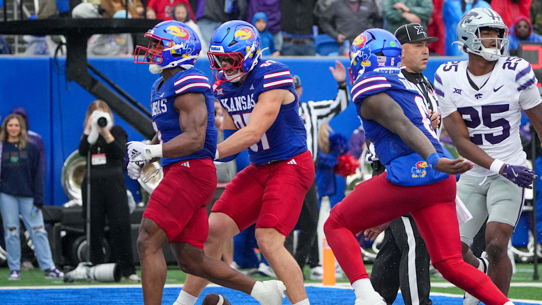 Oct 25, 2025; Lawrence, Kansas, USA; Kansas Jayhawks running back Daniel Hishaw Jr. (9) celebrates with team mates against the Kansas State Wildcats after scoring during the first half of the game at David Booth Kansas Memorial Stadium. Mandatory Credit: Denny Medley-Imagn Images