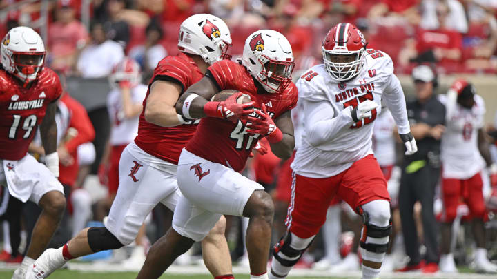 Aug 31, 2024; Louisville, Kentucky, USA;  Louisville Cardinals defensive lineman Ramon Puryear (41) returns a fumble recovery against Austin Peay Governors offensive lineman Chinazo Obobi (55) during the second half at L&N Federal Credit Union Stadium. Louisville defeated Austin Peay 62-0. 