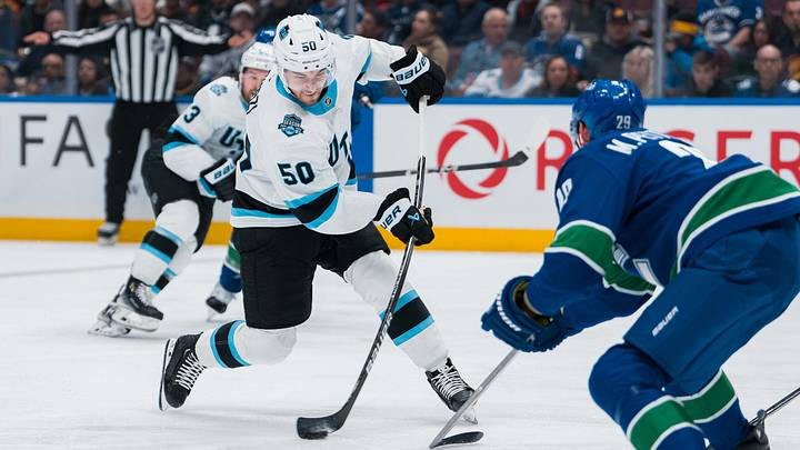 Mar 16, 2025; Vancouver, British Columbia, CAN; Utah Hockey Club defenseman Sean Durzi (50) shoots against the Vancouver Canucks in the second period at Rogers Arena. Mandatory Credit: Bob Frid-Imagn Images
