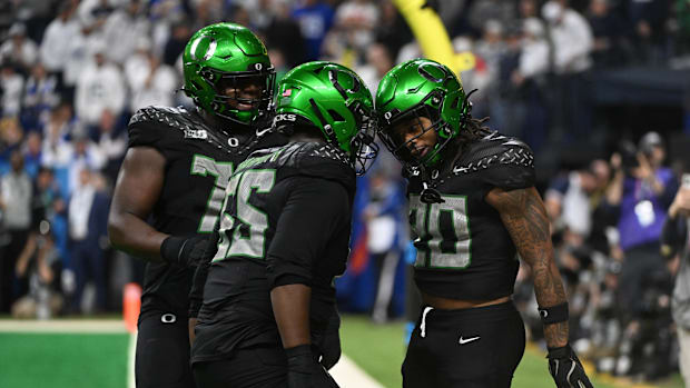 Dec 7, 2024; Indianapolis, IN, USA; Oregon Ducks running back Jordan James (20) and offensive lineman Marcus Harper II (55) c