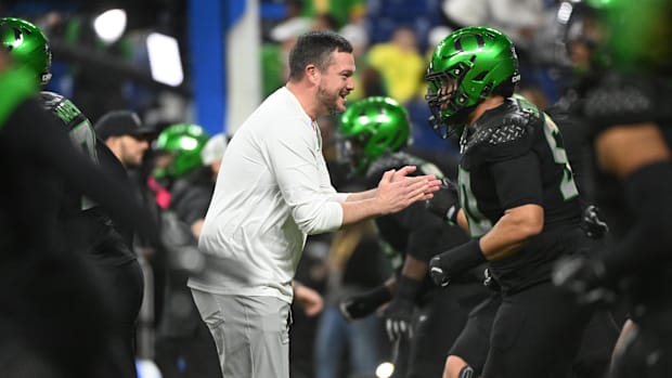 Dec 7, 2024; Indianapolis, IN, USA; Oregon Ducks head coach Dan Lanning talks to players prior to facing the Penn State Nitta