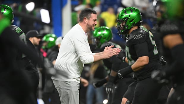 Dec 7, 2024; Indianapolis, IN, USA; Oregon Ducks head coach Dan Lanning talks to players prior to facing the Penn State Nitta