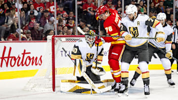 Apr 5, 2025; Calgary, Alberta, CAN; Vegas Golden Knights goaltender Akira Schmid (40) makes a save as Calgary Flames center Martin Pospisil (76) and Vegas Golden Knights defenseman Alex Pietrangelo (7) compete for position during the second period at Scotiabank Saddledome. Mandatory Credit: Brett Holmes-Imagn Images