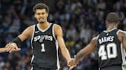 Dec 29, 2024; Minneapolis, Minnesota, USA; San Antonio Spurs center Victor Wembanyama (1) celebrates with San Antonio Spurs guard Devin Vassell (24) and San Antonio Spurs forward Harrison Barnes (40) after making a shot against the Minnesota Timberwolves in the second half at Target Center.