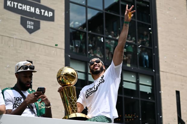 Boston Celtics star Jayson Tatum waves to the crowd during the team's 2024 NBA championship parade.