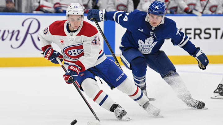 Sep 26, 2024; Toronto, Ontario, CAN;  Montreal Canadiens forward Lane Hutson (48) controls the puck in front of Toronto Maple Leafs forward Bobby McMann (74) in the third period at Scotiabank Arena. Mandatory Credit: Dan Hamilton-Imagn Images
