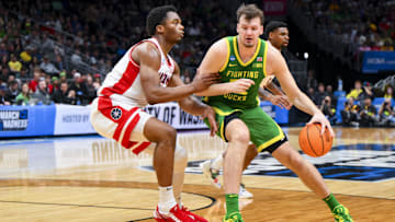 Mar 23, 2025; Seattle, WA, USA;  Oregon Ducks center Nate Bittle (32) dribbles the ball against Arizona Wildcats forward Tobe Awaka (30) in the first half at Climate Pledge Arena. Mandatory Credit: Steven Bisig-Imagn Images