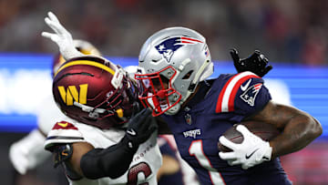 Washington Commanders cornerback Noah Igbinoghene tackles New England Patriots receiver Ja'Lynn Polk.