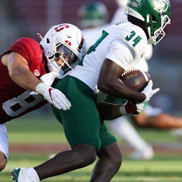 Sep 7, 2024; Stanford, California, USA; Cal Poly Mustangs running back Kendric Sanders (34) is tackled by Stanford Cardinal linebacker Tristan Sinclair (8) during the second half at Stanford Stadium. Mandatory Credit: Sergio Estrada-Imagn Images